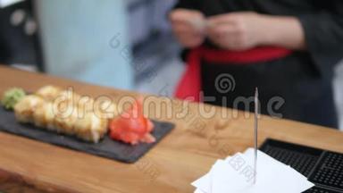 特写-服务员把寿司放在餐厅的桌子上